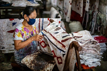 A batik craftsman is making batik. Batik is one of Indonesia's cultural heritage which has become an icon of UMKM and national clothing that has gone global. - obrazy, fototapety, plakaty