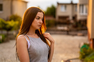 Young beautiful woman in gray dress at sunset