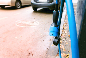 Close up of electric car charging hose end empty emobility parking spot for electric car.