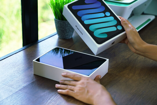 BANGKOK, THAILAND - OCTOBER 1, 2021: Close up hand opening box of new Ipad mini gen 6 order from Apple store online