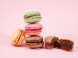 Sweet chocolate macarons, on a pink background.