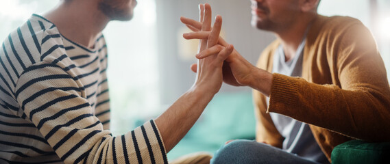 Authentic Close Up Shot of a Stylish Attractive Young Adult Gay Couple Spend Time at Home. Two Happy Men in Love in Casual Clothes Gently Hold Hands. Cute LGBT Relationship Content.