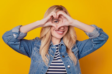 Portrait of affectionate inspired girlfriend show heart gesture cover eye on yellow background