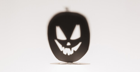 Halloween background concept. Jack O pumpkin angry face shadow. Spooky smiling shadow of an orange pumpkin lantern top view close up, Halloween party design