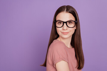 Portrait of young intelligent woman wearing glasses against violet background