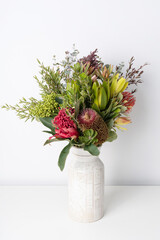 Beautiful floral arrangement of Australian native flowers, including purple banksia, red Waratah,...