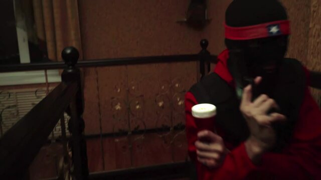 a thief with a gun and a flashlight climbs the stairs