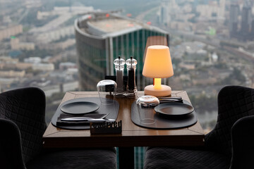 Obraz na płótnie Canvas Dinner at sunset with panoramic views of the Moscow business center. Dinner on the background of the city. Restaurant overlooking downtown. Romantic setting, Moscow, Russia
