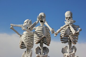 Hear no evil, see no evil, say no evil with a skeleton of the person
