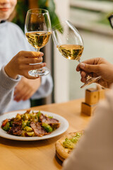 woman with husband holding glasses of white wine
