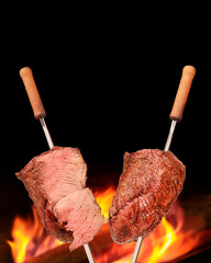 Barbecued Picanha barbecue with blurred fire in the background. Also called churrasco.