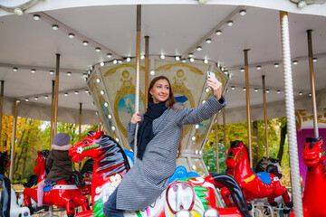 Smiling woman riding a horse on carousel