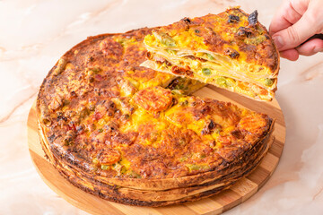 Delicious homemade pie with vegetables on wooden plate
