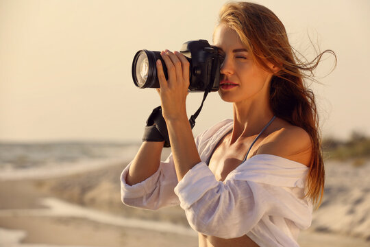 Photographer taking photo with professional camera near sea