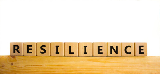 Resilience symbol. Word 'Resilience' written on wooden blocks. Copy space. Beautiful wooden table, white background. Business and resilience concept.