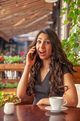 Young beautiful woman get very good news on phone and get very happy.