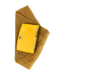 Rectangular piece of moldy cheese on craft paper. Top view.