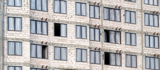 Windows and walls on construction site of multi storey building texture. Modern civil engineering. Buildings industry. Urban construction. Unfinished building. Concrete structures.