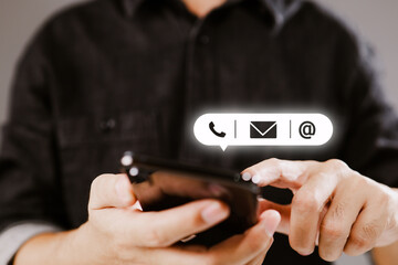 CONTACT US. Customer support concept, copy space. Hand of Businessman holding mobile smartphone with ( mail,phone,email ) icon.