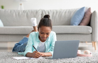 Pensive teenager afro american female student study at home with laptop, prepare for test and exam...