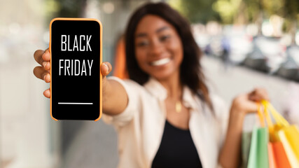 Woman showing cell phone with black friday text on screen