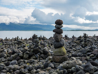 Stones stacked up in cairns on a shore in Reykjavik, Iceland.