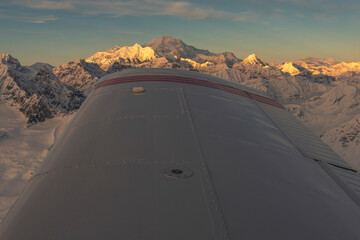 Aerial view of Denali at sunset with airplane wing
