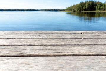 Fototapeta premium Pier on the lake.Wooden bridge forest in spring autumn time with blue lake. Lake for fishing with pier.Copy space.