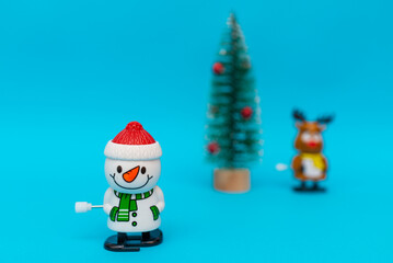 Front view Toys Snowman, deer, gift boxes on blue background with copy space