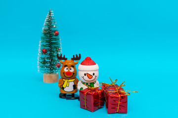 Toys Snowman, deer, gift boxes on blue background with copy space.Selective focus.