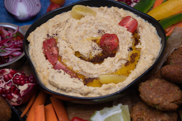 Mediterranean food spread with hummus, falafel, roasted pepper dip, yogurt sauce, crudites