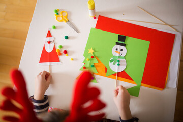 Fototapeta premium paper craft for kids. girls play with homemade toys Santa Claus and snowman. create fun art for children. new year concept