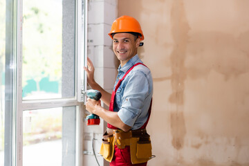 Man worker mounting window in a renovated building