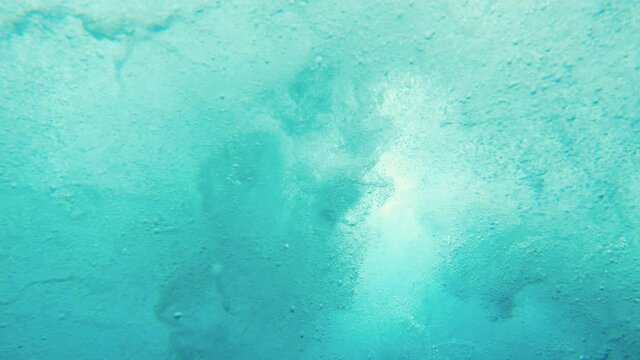 Underwater view of young man surfing in South Male Atoll
