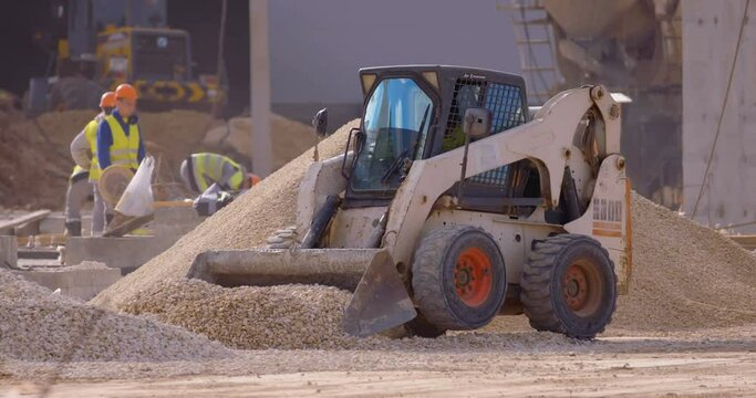 Excavation at a construction site, mini loader bobcat transports crushed stone to different construction places, where it is advisable to use compact construction equipment