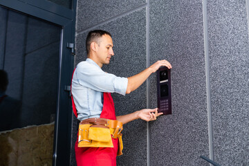 Builder installing an intercom. renovation in a renovated building