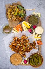 Vegan cauliflower wings and battered airfried vegetables , crudites with assorted crudites and sauces