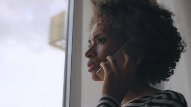 Young woman having unpleasant phone conversation, upset with bad news, divorce