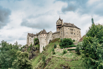 Fototapeta na wymiar Panoramic view of famous medieval town of Loket,Elbogen, with colorful houses and stone castle above river,Czech Republic.Historical city centre is national monument.Travel architecture background.