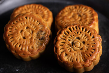 Mooncakes in a vintage tray Chinese festive snacks on black background