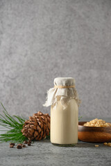 Cedar nut milk on gray background. Non dairy alternative milk plant based lactose free. Healthy vegan beverage. Vertical format.