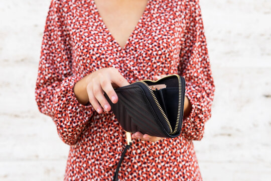 Female in dress opening black purse