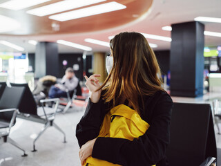 woman sitting at the airport looking to the side of the waiting passenger