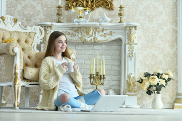 Portrait of beautiful teen girl sitting on floor near vintage armchair
