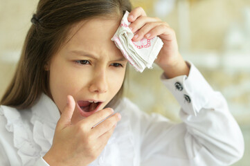 Portrait of sick little girl holding handkerchief