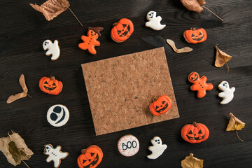 Halloween orange and white gingerbread cookies lie on a dark wooden table. Halloween concept with homemade cookies
