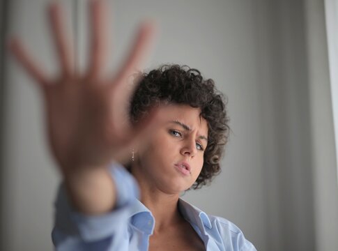 young woman with refusal gesture raises her right hand