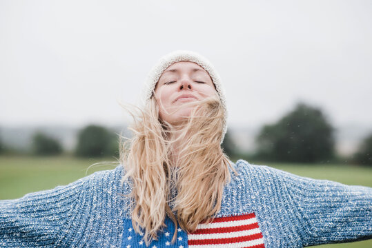 woman wearing the American flag enjoying the wind and rain in her hair