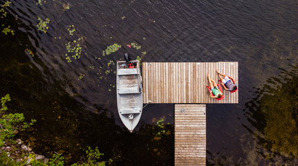 Overhead aerial image of couple sitting on a dock together.