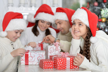Happy family in Santa hats preparing for Christmas